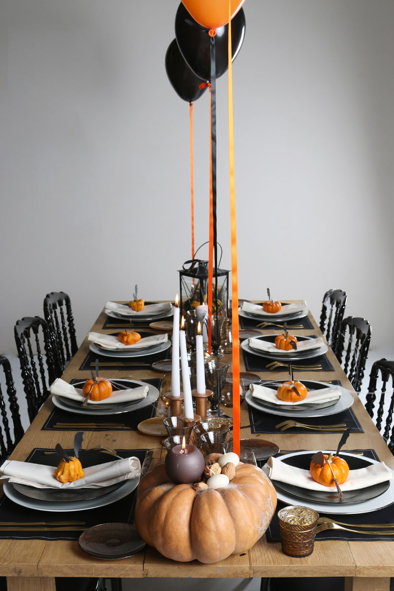 Table d'halloween orange et noire avec citrouilles et ballons