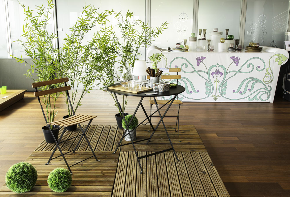 Mise en scène de table et chaises de jardin décorées de plantes artificielles